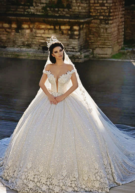 This statement-making ball gown from Frida Xhoi & Xhei featuring deep-v neckline and glittering embellishments is making us swoon!
