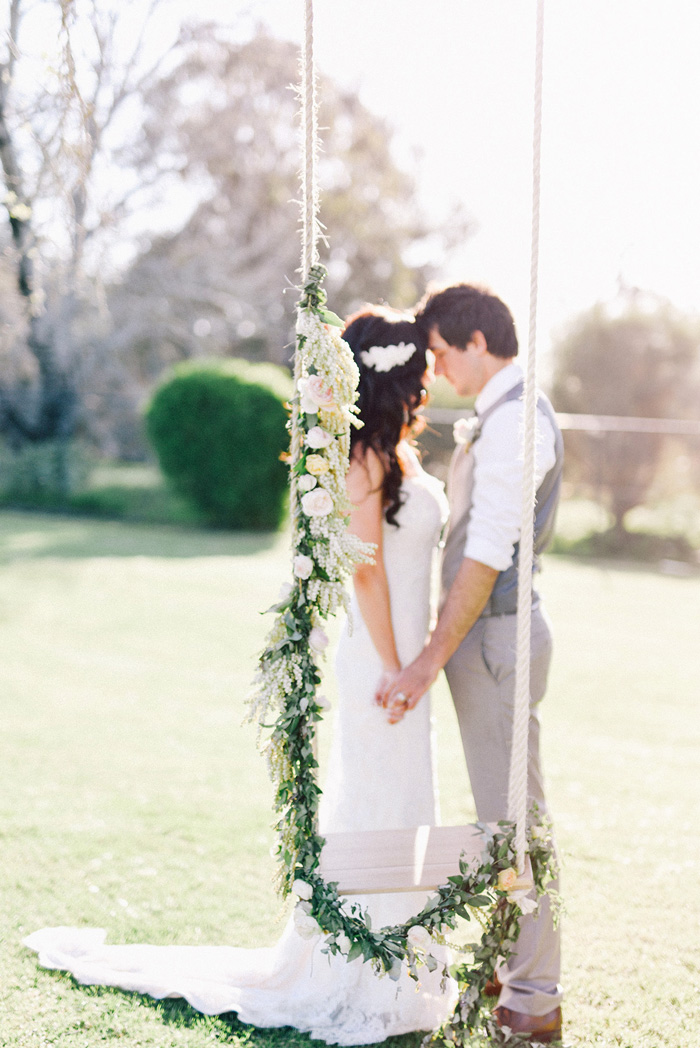 Romantic rustic engagement session with floral swing