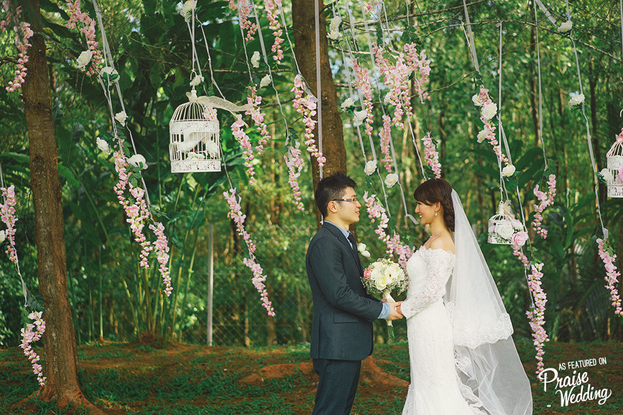 This wedding photo has the perfect floral backdrop, rich colors, and an adorable couple seriously in love!