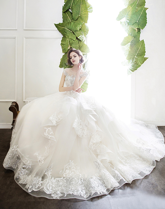 Can't take our eyes off this gorgeous creation by Tyche Dress, featuring romantic floral lace and layered ruffles!